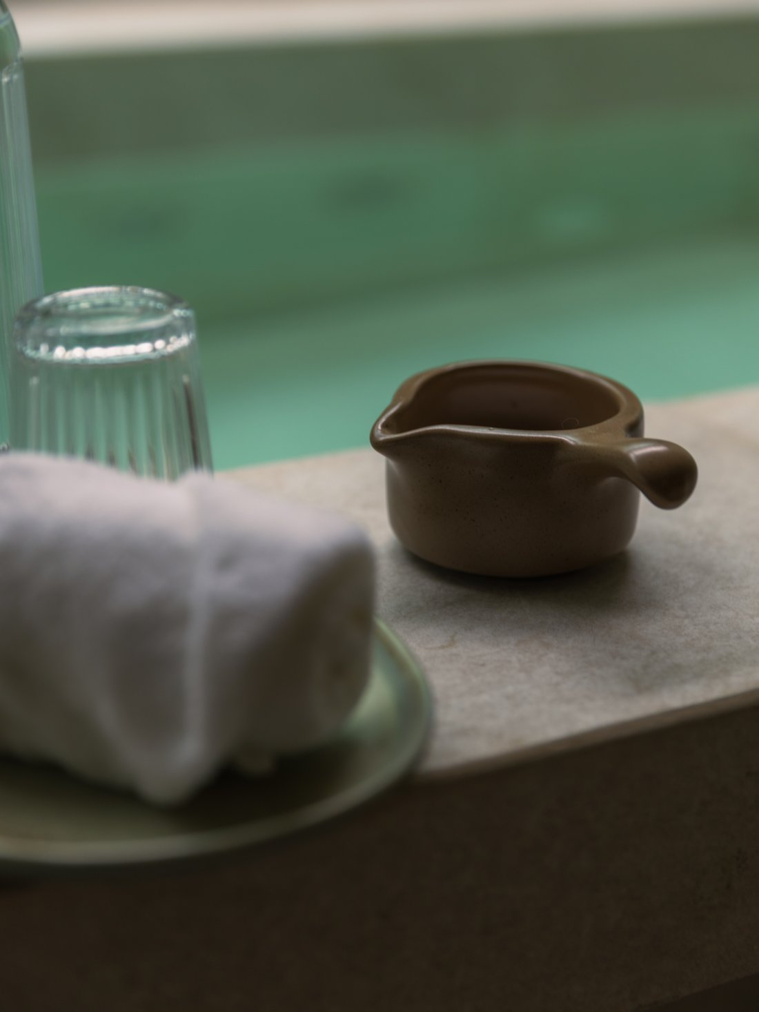 VATA Signature ritual — carafe, towel and stone bowl on the onsen ledge