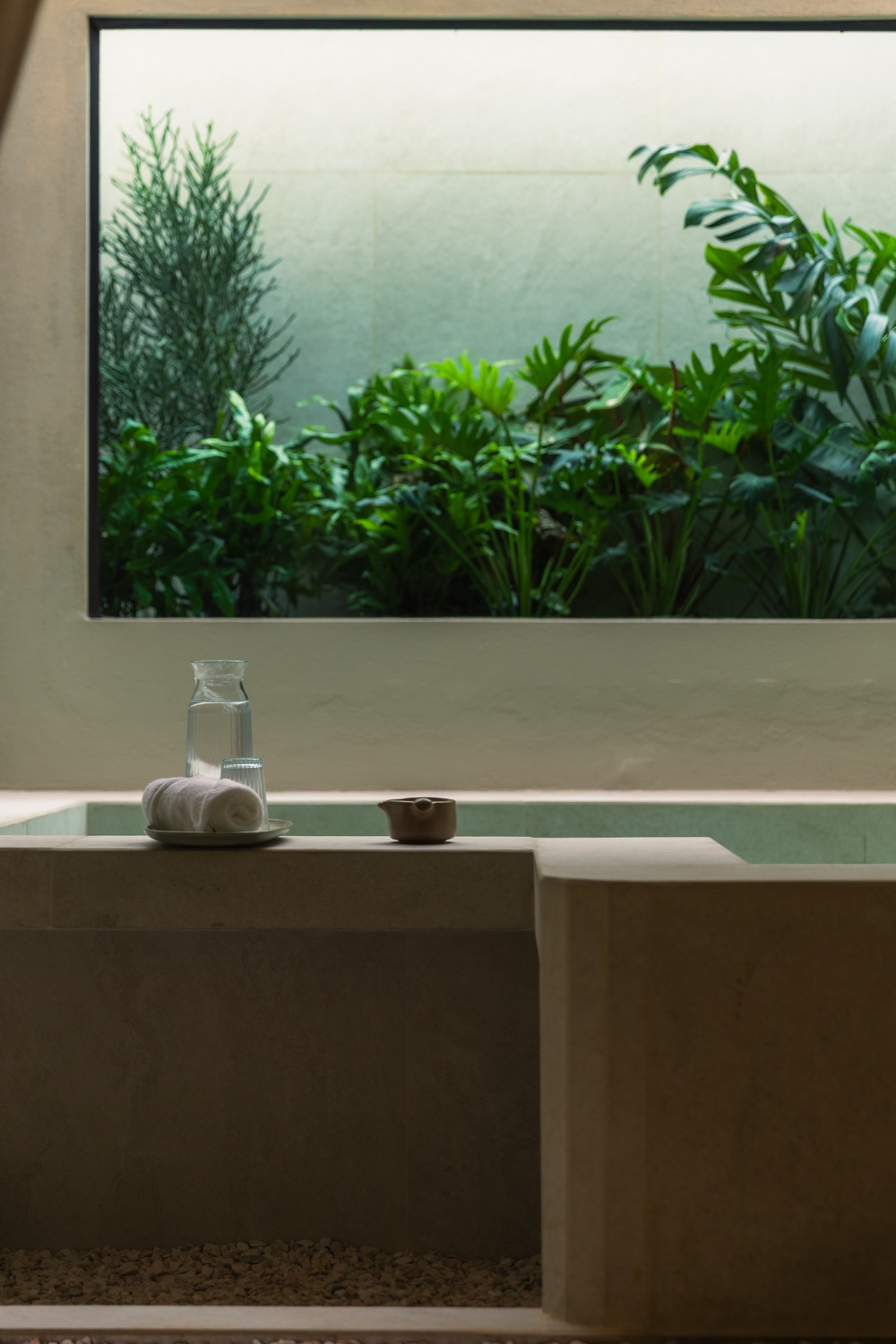 Glass onsen room overlooking mirror garden